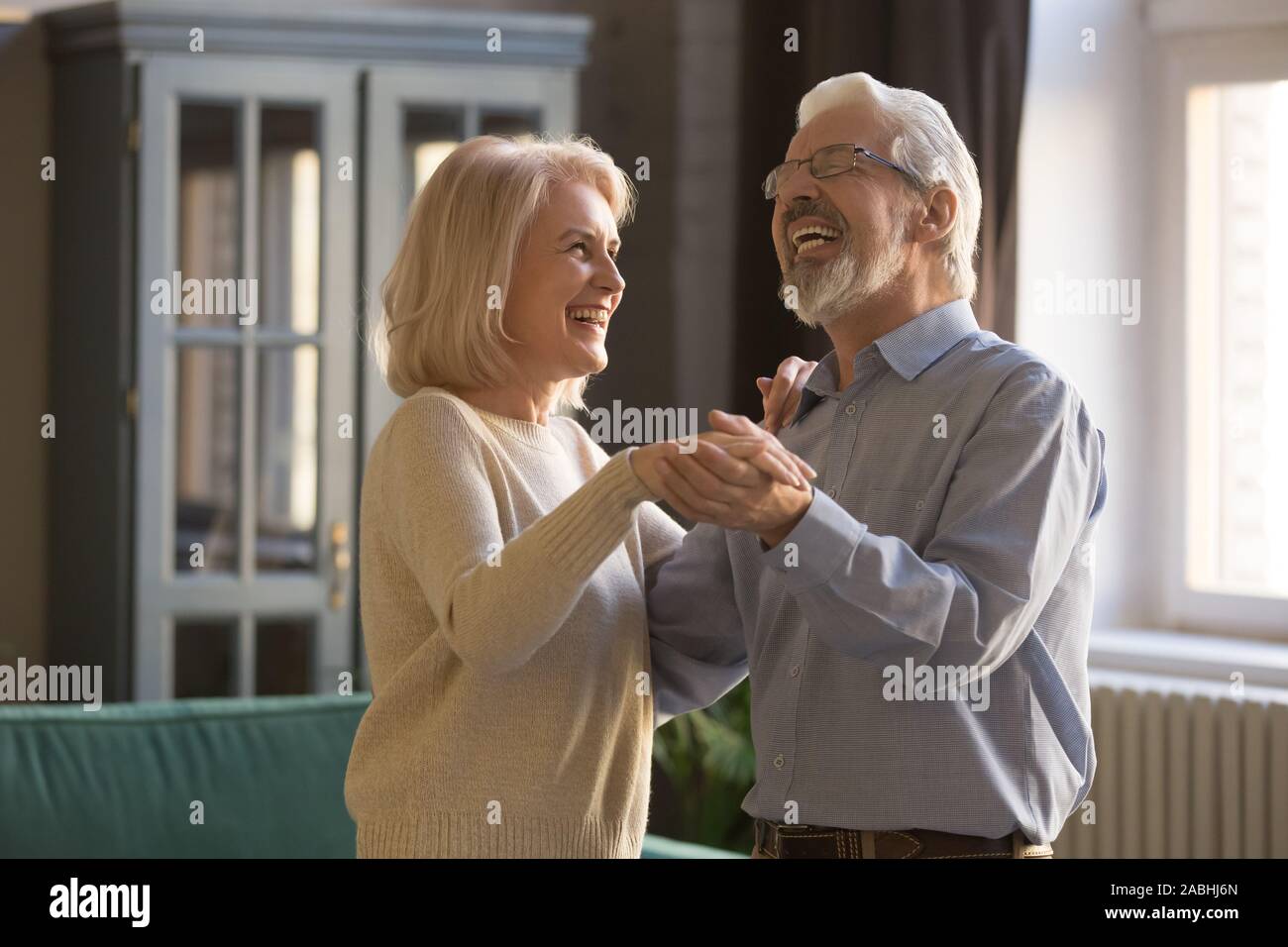 Freundliche ältere Ehepartner tanzen freie Zeit zu Hause genießen Stockfoto