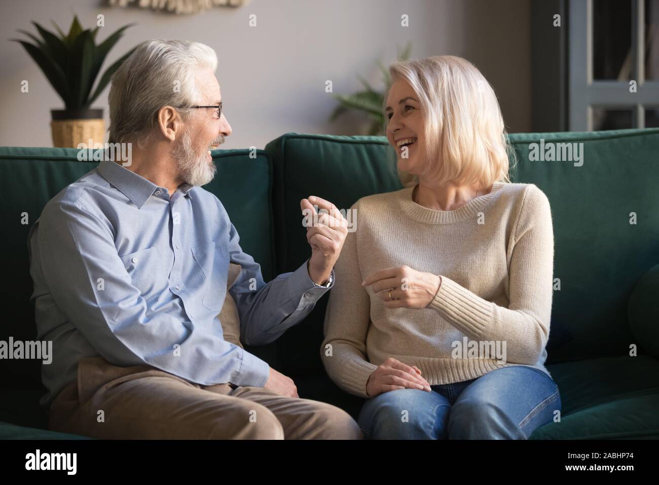 Freundliche ältere Eheleute sitzen auf der Couch chatten Glücklich Stockfoto