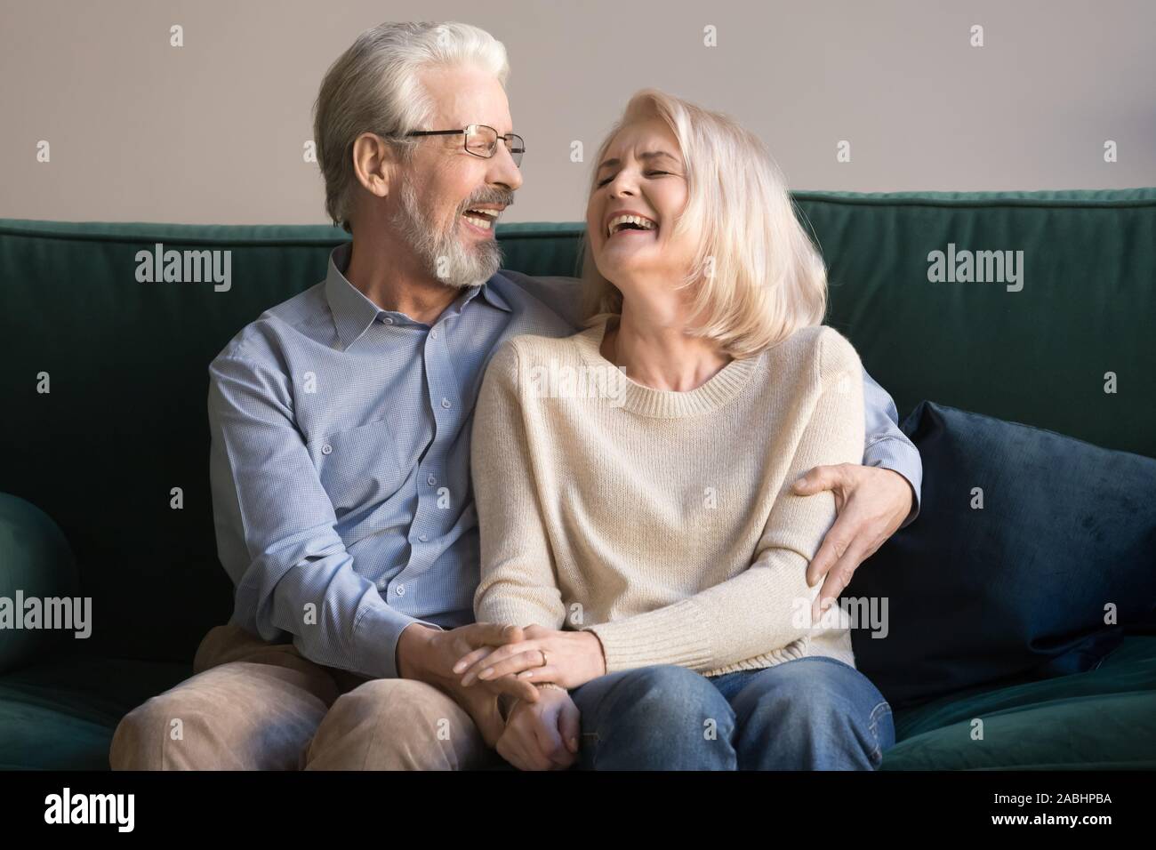 Überglücklich Lachen senior Paar, sitzen auf der Couch Stockfoto