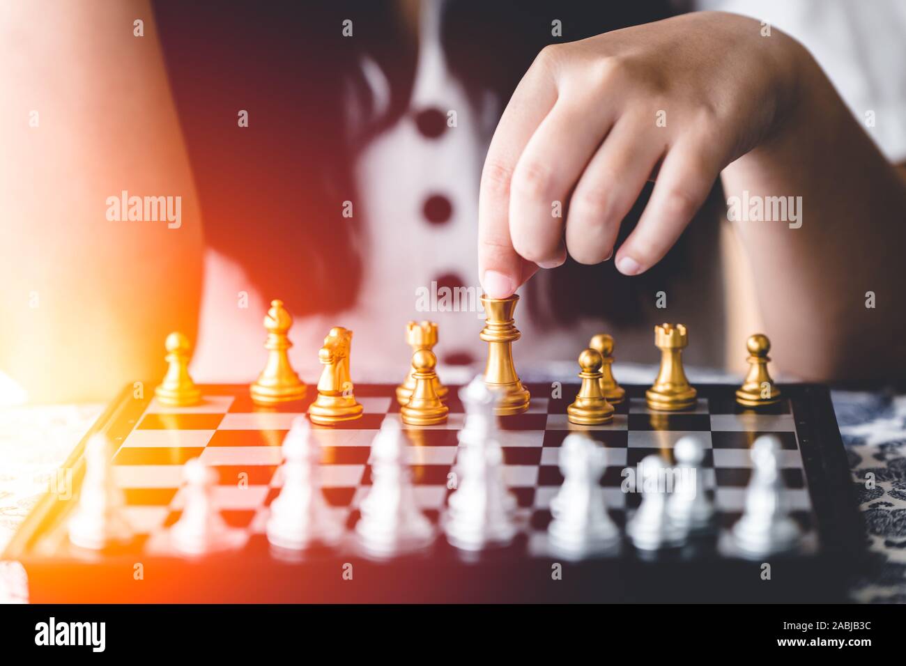 Closeup Mädchen Hand spielt Schach Brettspiel für Gehirn und Strategie Schulungskonzept. Stockfoto