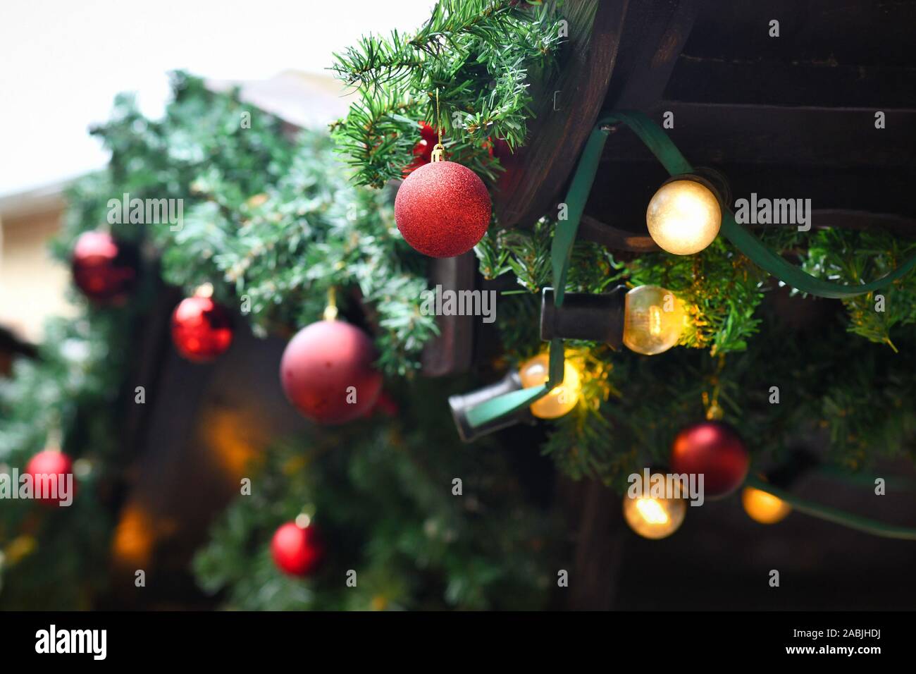 Weihnachtsbaum mit künstlichem Schnee mit Tannenzapfen und Red tree ornament Flitter und Lichterkette im Hintergrund Stockfoto
