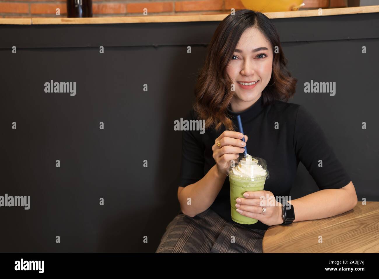 Frau trinken grünen Tee frappe in einem Cafe Stockfoto