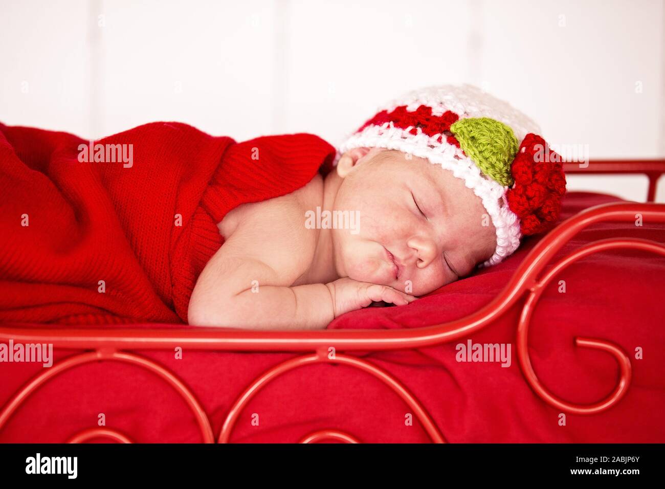 Mackay, Queensland, Australien - August 2014: Neugeborene Fotografie von  einem Baby Mädchen friedlich schlafend in einem roten Bett unter einer roten  Decke Stockfotografie - Alamy