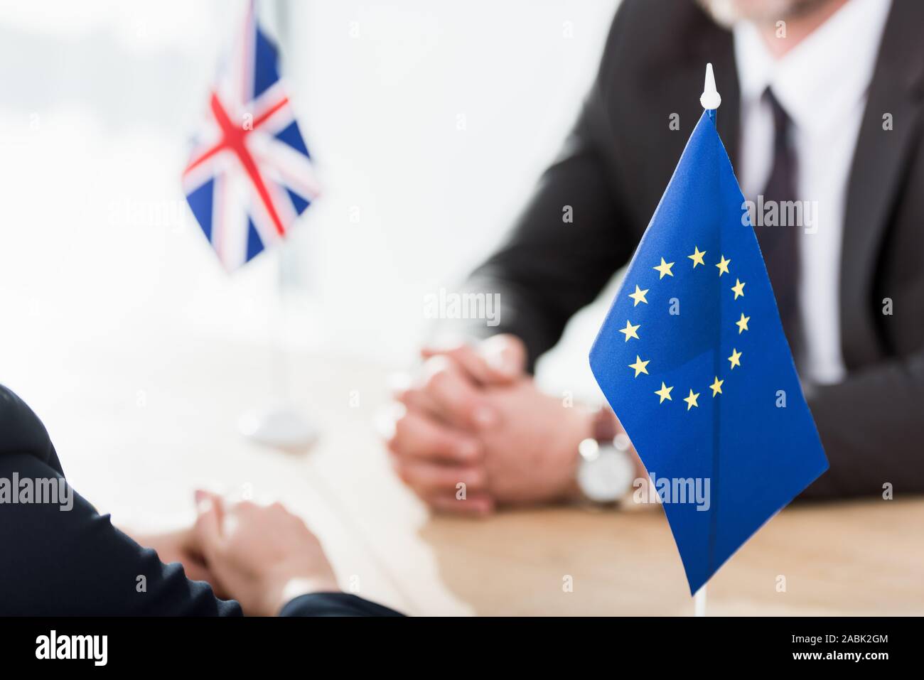 Selektiver Fokus der Fahne der Europäischen Union in der Nähe von Botschafter mit geballten Händen Stockfoto