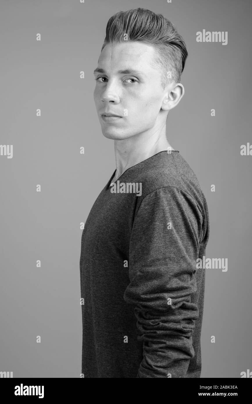 Porträt der jungen Menschen gegen den grauen Hintergrund in Schwarz und Weiß Stockfoto