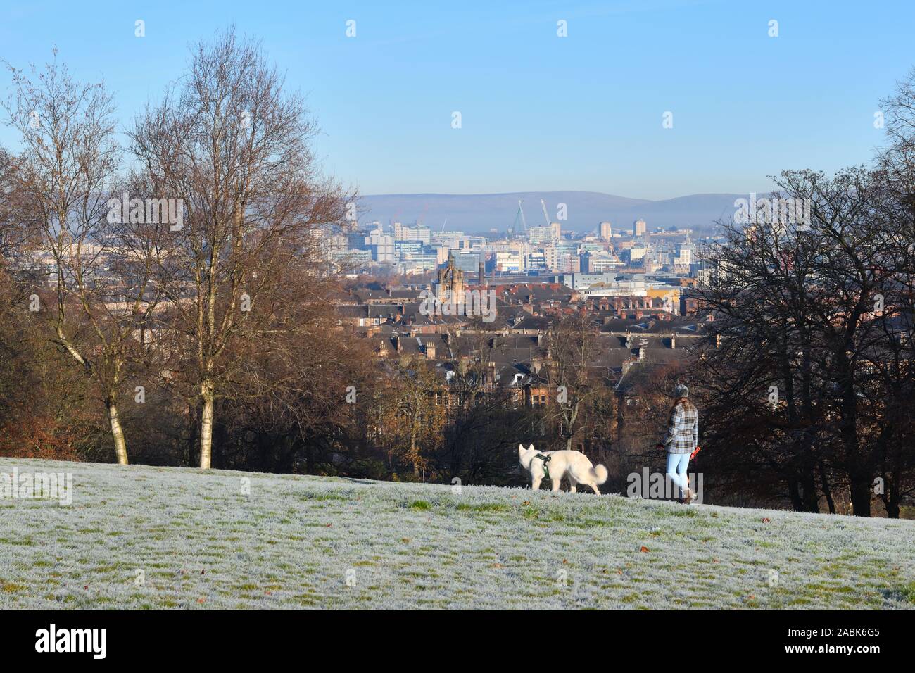Mädchen gehen Hund im Queen's Park in der Stadt Glasgow an einem sonnigen Morgen unter dem Gefrierpunkt in Schottland, Großbritannien, Europa Stockfoto