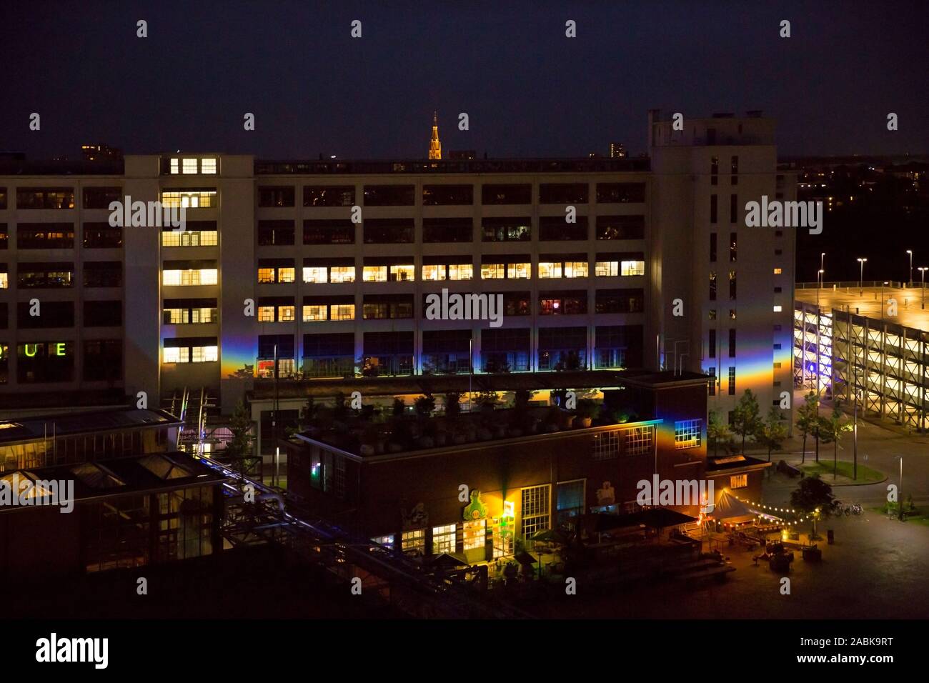 Strijp S Eindhoven, Niederlande, 30. Juni 2016. Nacht Blick auf der Ketelhuisplein und die klokgebouw Strijp S mit einem großen Prisma rainbow Reflexion Stockfoto