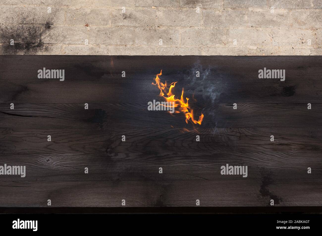 Detail eines brennenden großen Stück Eichenholz, nur mit einer brennenden Fackel verbrannt, Erstellen von Flammen und Rauch, alte jappanese Shou sugi Verbot Technik. Schwarz woode Stockfoto