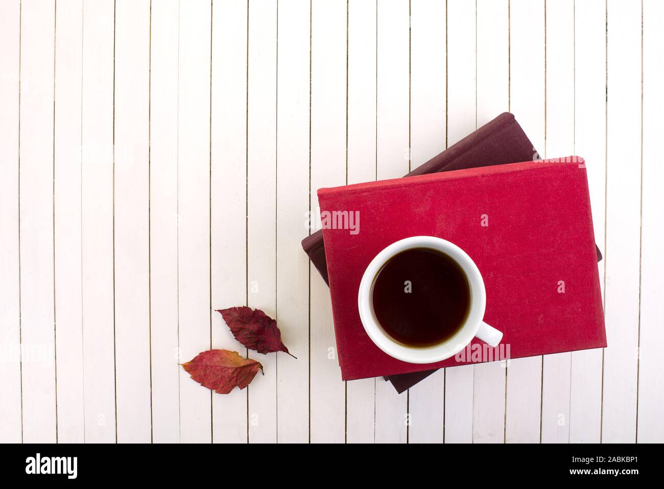 Rote und weiße Tasse Kaffee auf der Vintage White Holz- Hintergrund. Kaltes Wetter und herbstliche Stimmung Stockfoto