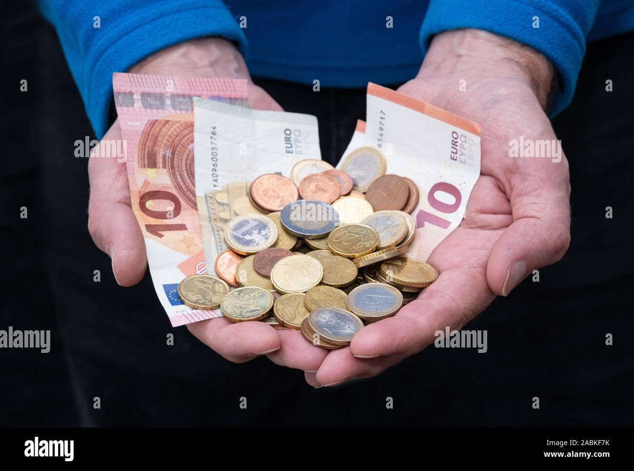 Männliche Hände halten viele Euro in bar Stockfoto