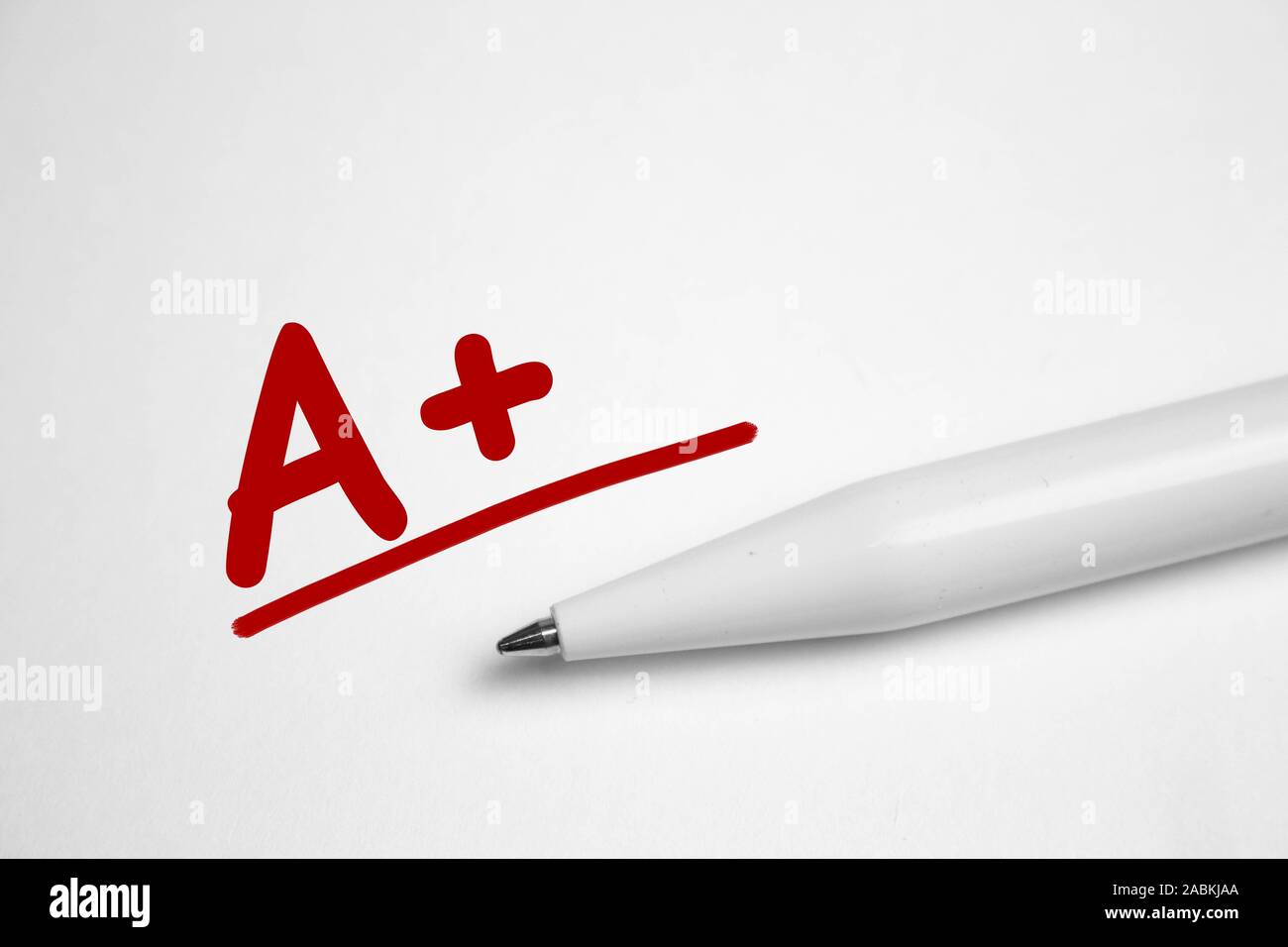 Ein plus mit roter Stift auf Notebook Papier geschrieben. Stockfoto