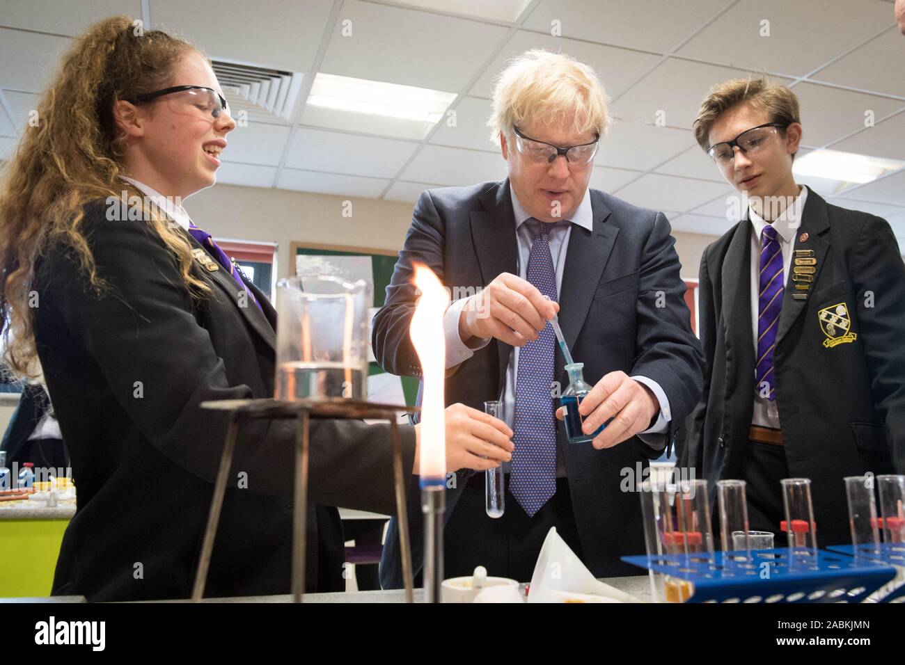 Premierminister Boris Johnson hilft Mit einer Wissenschaft Demonstration mit Ruby Cutler (links), Jahr 11 Schulsprecherin und Matthäus, aufrecht, Jahr 11 Schulsprecher, bei einem Besuch der Hochschule in Chulmleigh Chulmleigh, Devon, während auf dem allgemeinen Wahlkampagne Trail. Stockfoto