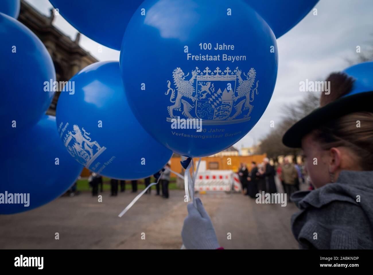 Ein Mädchen aus der Gruppe der Kinder der Goldbergler Helfendorf Trachtenverein hält ein Ballon am Hofgarten in München anlässlich des 100-jährigen Jubiläums des Freistaates Bayern. [Automatisierte Übersetzung] Stockfoto