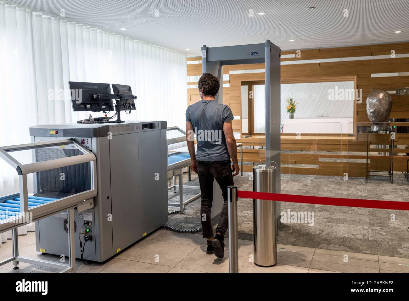 Ein Besucher der Beschwerdekammern des Europäischen Patentamts in Haar geht durch die Sicherheitskontrolle im Eingangsbereich. [Automatisierte Übersetzung] Stockfoto