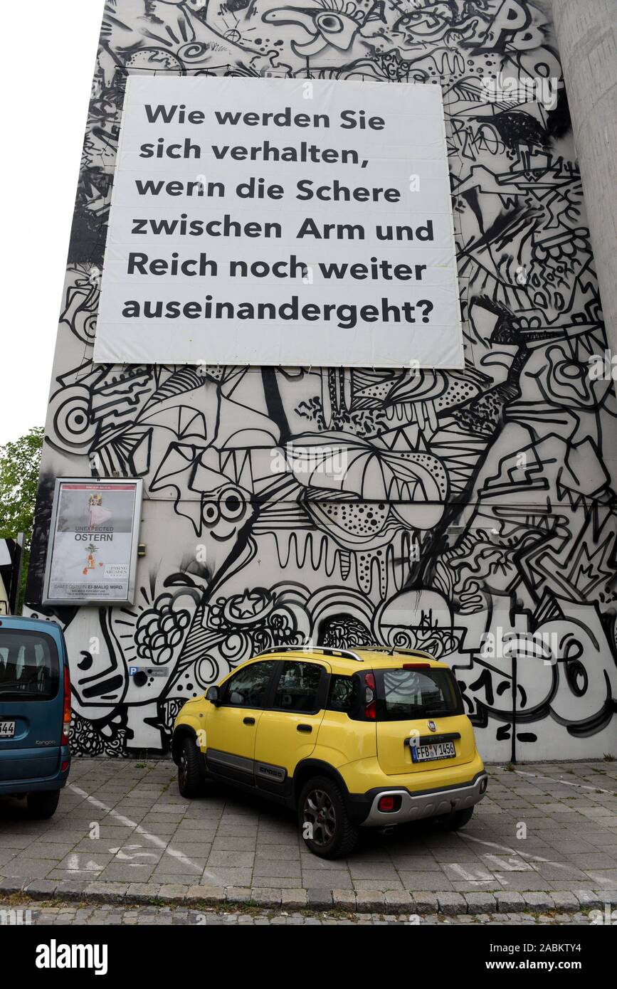 In der Kunst, stellt sich die Frage: "Wie werden Sie sich verhalten, wenn die Schere zwischen Arm und Reich noch weiter auseinander? Die Mitglieder der 'Abteilung' diese Frage öffentlich auf Plakaten bitten. Das Bild zeigt ein großes Plakat mit der Frage auf einem Haus Wand über einen Parkplatz. [Automatisierte Übersetzung] Stockfoto