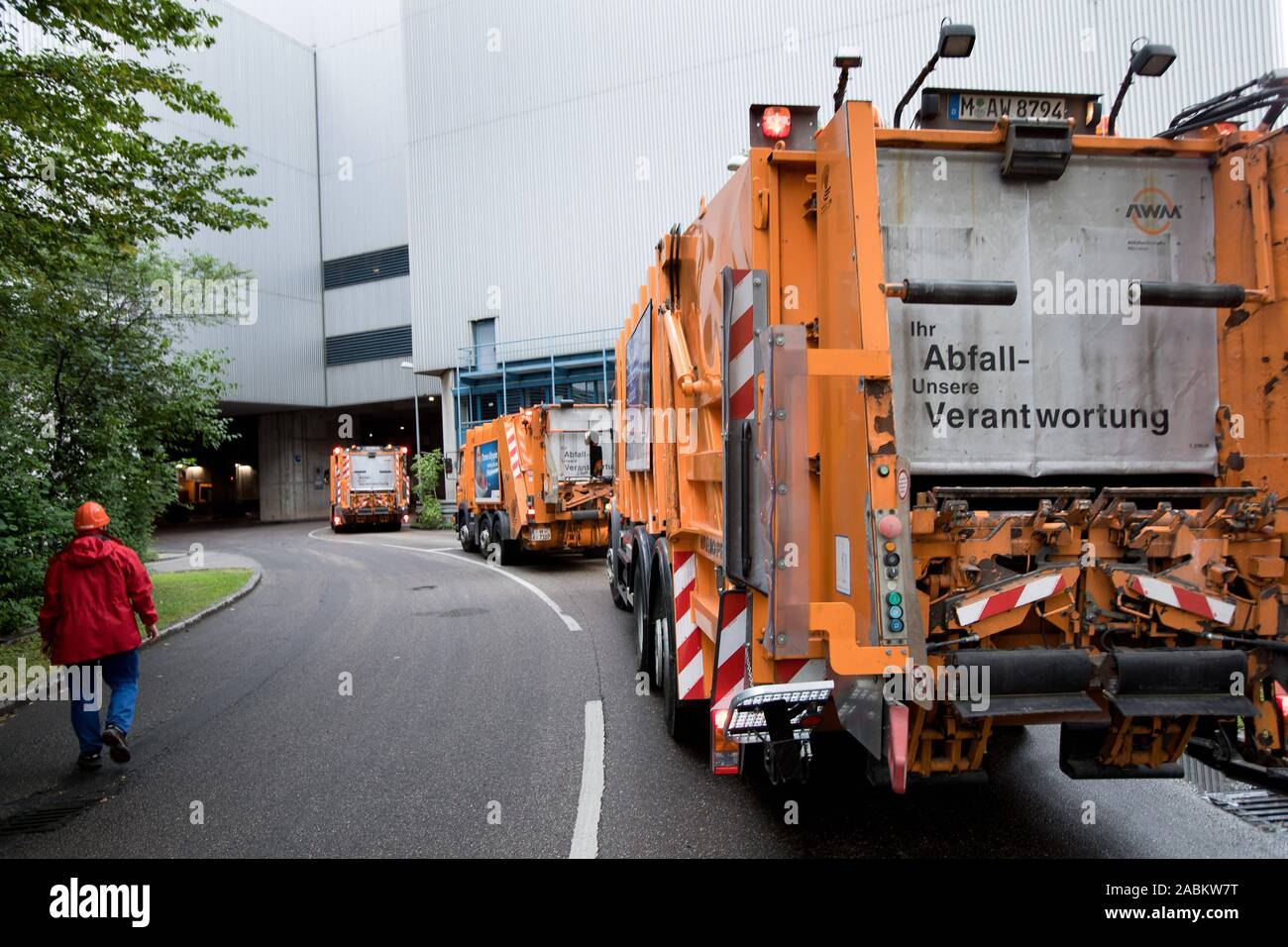 Entsorgung von Restmüll durch die kommunalen Entsorgungsunternehmen München (AWM). Müllwagen fahren Sie in Richtung müll Lieferung der Blockheizkraftwerk [automatisierte Übersetzung] Stockfoto