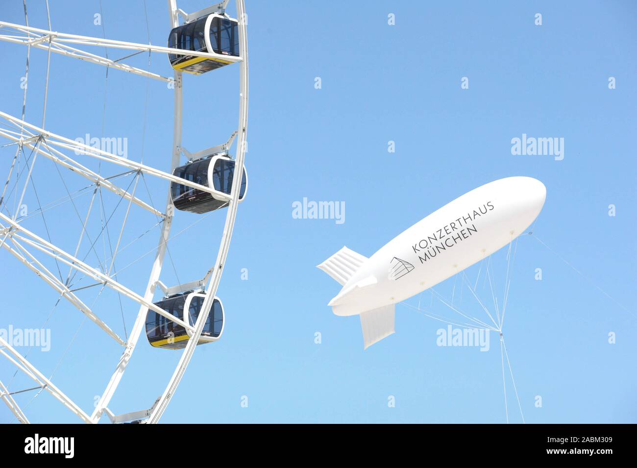 Zeppelin mit Werbung für die neue Konzerthalle oberhalb der Baustelle in der Fabrik Quartal hinter Ostbahnhof. Die neue Konzerthalle ist der Schauplatz des Symphonieorchesters des Bayerischen Rundfunks zu werden. [Automatisierte Übersetzung] Stockfoto