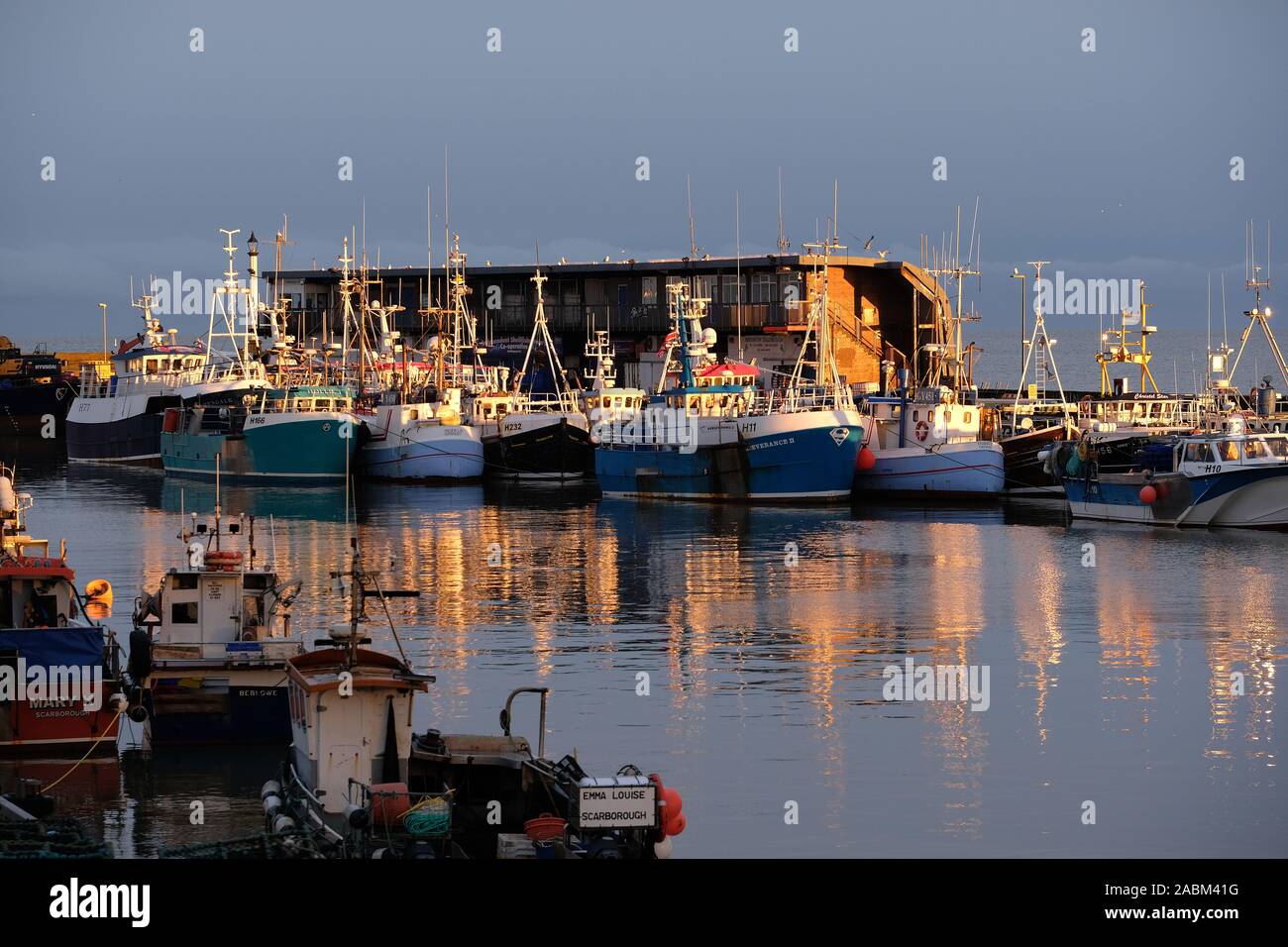 Fischereiflotte und bitte Boote in Bridlington Hafen im Abendlicht. Stockfoto