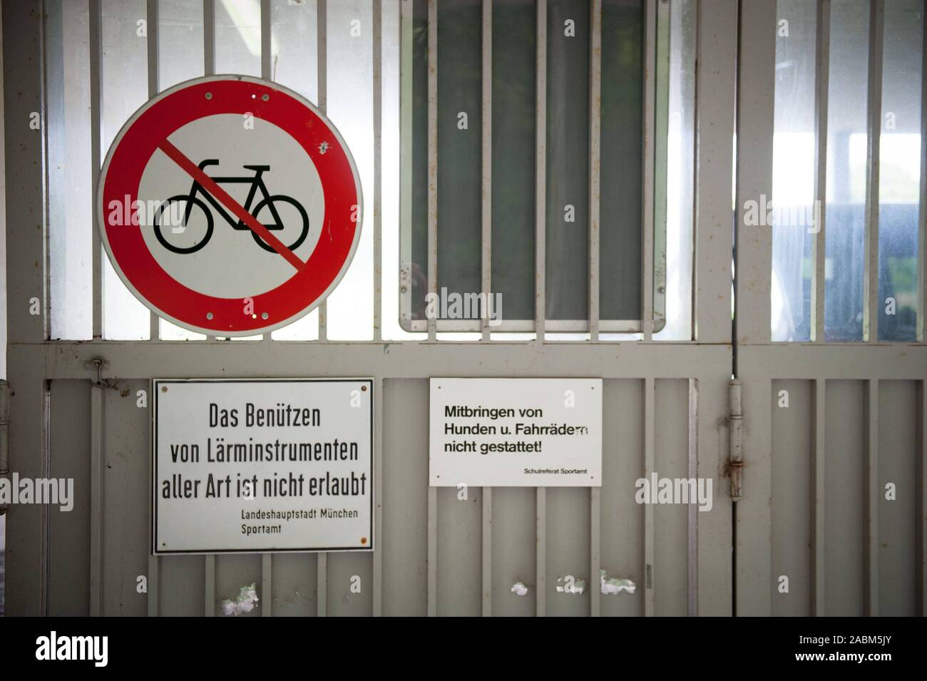 Mehrere Zeichen auf höglwörther Str. verbieten nicht nur Hunde und Fahrräder, sondern auch die "Verwendung von Lärm Instrumente aller Art" in der Sendlinger Bezirkssportanlage. [Automatisierte Übersetzung] Stockfoto