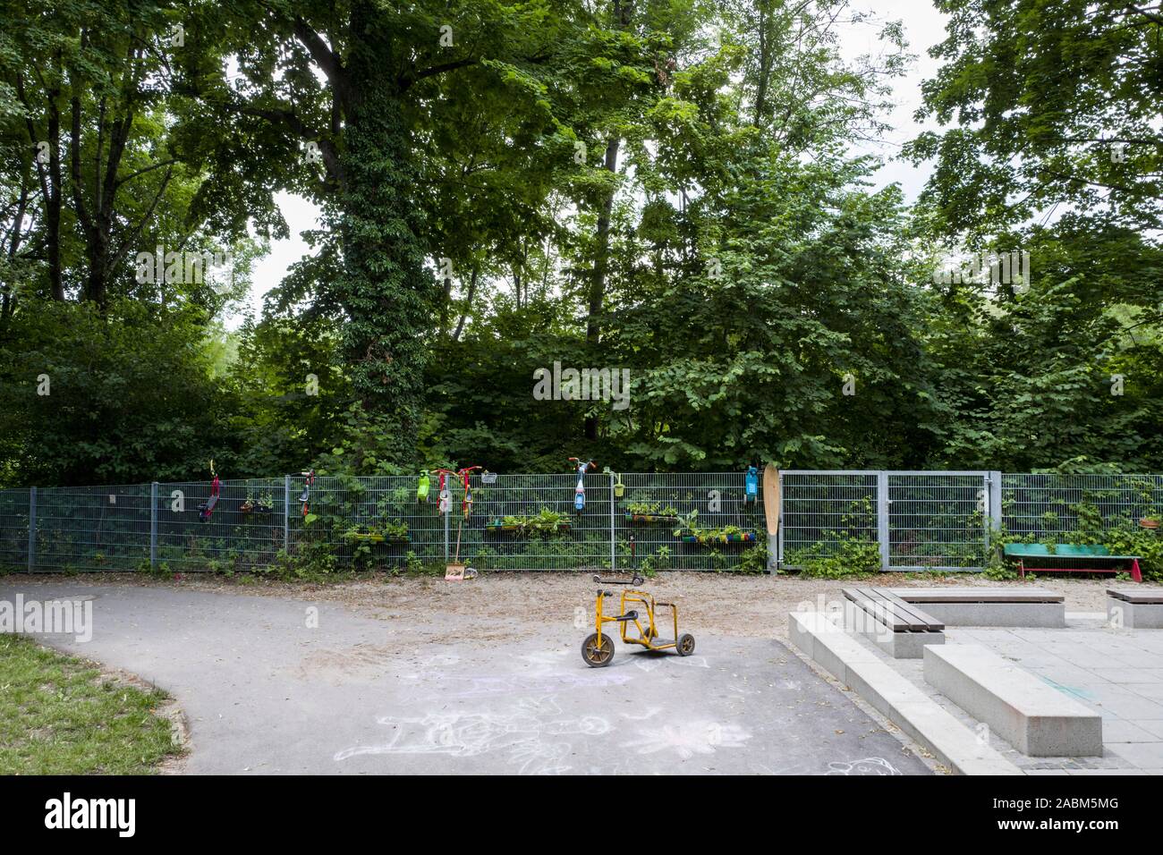 Ein Dreirad steht im Innenhof des Spervogelstraße in München. Der neue Zaun trennt den Kindergarten aus dem Wald, wo die Kinder spielen. [Automatisierte Übersetzung] Stockfoto