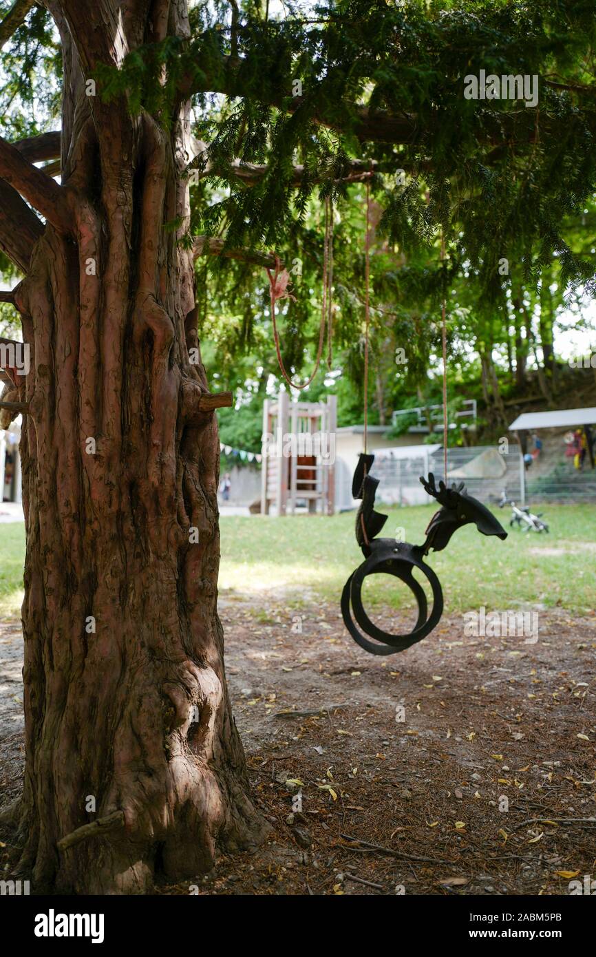 Eine Schaukel hängt von einem Baum in den Kinderzimmern Spervogelstraße in  München. [Automatisierte Übersetzung] Stockfotografie - Alamy