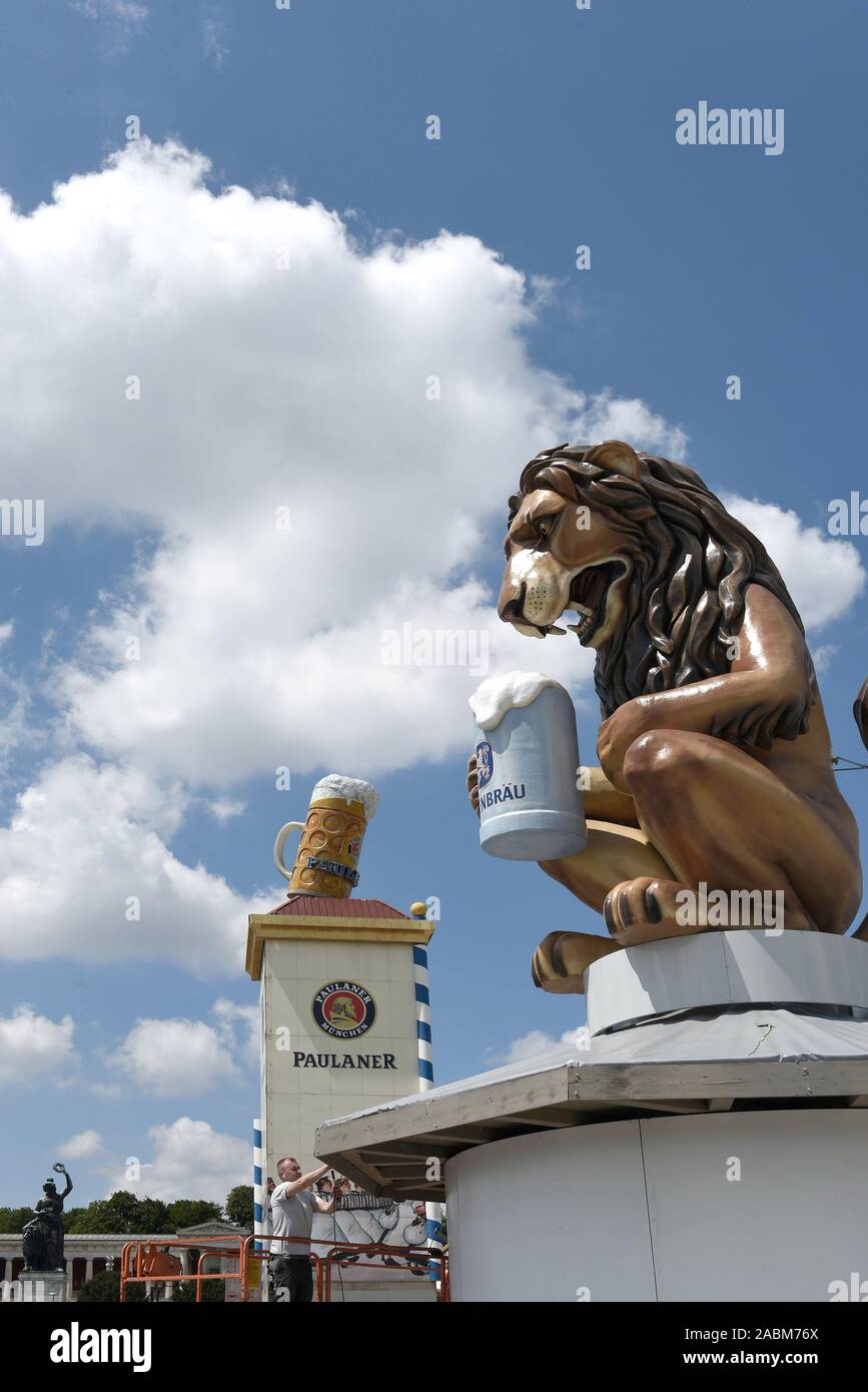 Set-up für das Oktoberfest 2019. Auf der rechten Seite eine übergroße Löwe Abbildung von Löwenbräu Bier trinken, wirbt im Hintergrund Paulaner Werbung erkennbar. [Automatisierte Übersetzung] Stockfoto