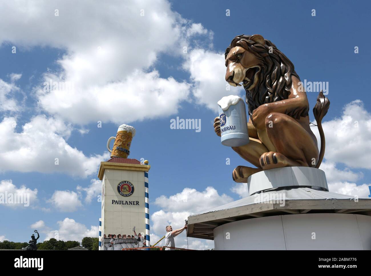 Set-up für das Oktoberfest 2019. Auf der rechten Seite eine übergroße Löwe Abbildung von Löwenbräu Bier trinken, wirbt im Hintergrund Paulaner Werbung erkennbar. [Automatisierte Übersetzung] Stockfoto