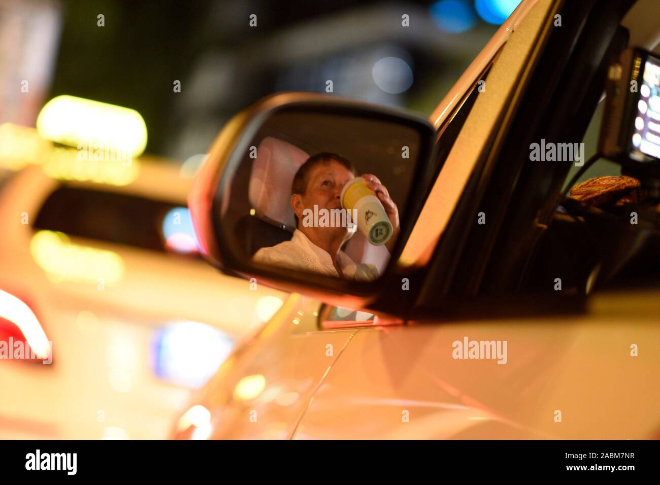 Ein Taxifahrer wartet auf Kunden an der Münchner Freiheit stehen in der Nacht. [Automatisierte Übersetzung] Stockfoto