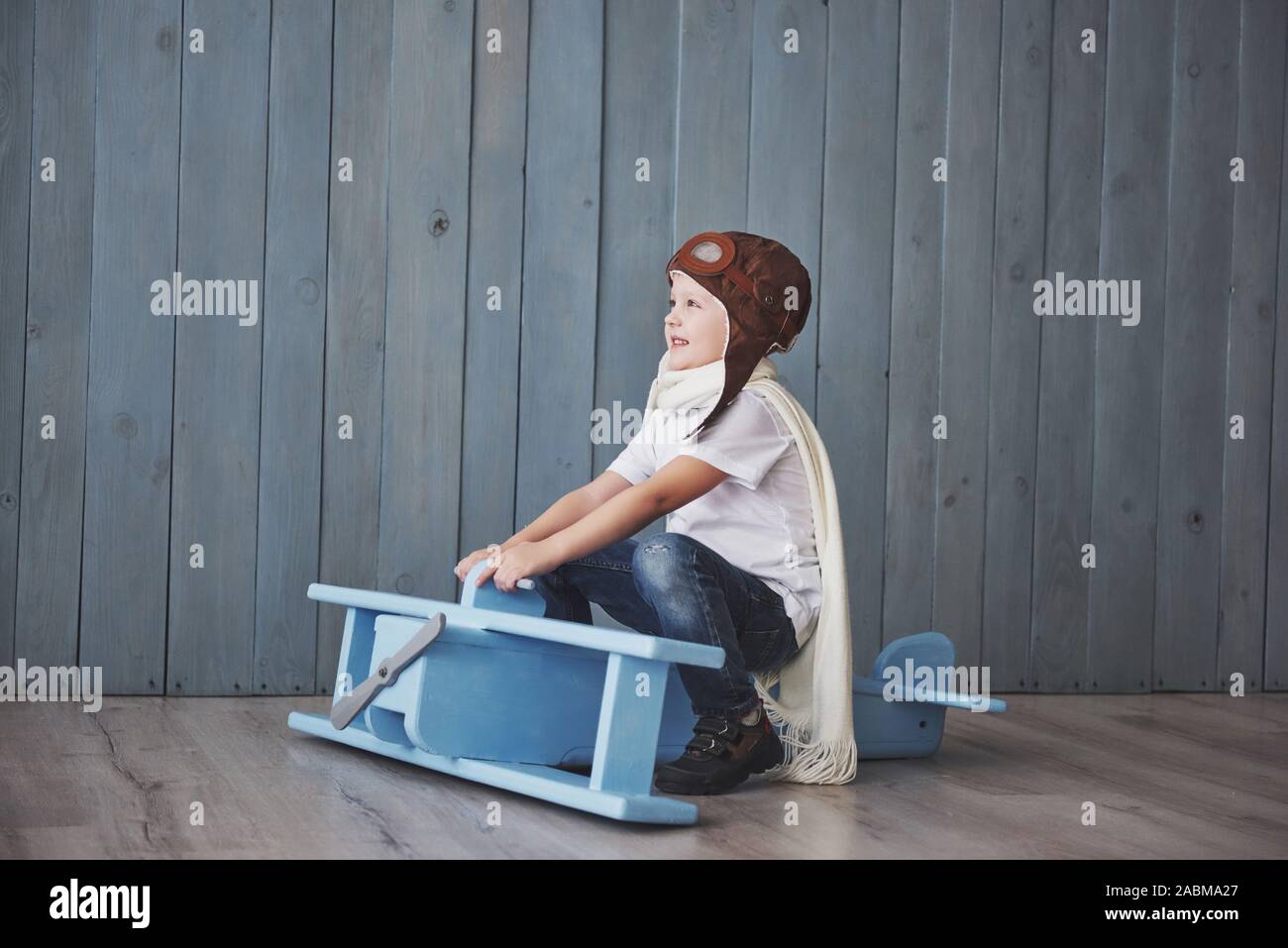Glückliches Kind in Pilot hat das Spielen mit Holz- Flugzeug gegen. Kindheit. Fantasie, Vorstellungsvermögen. Urlaub Stockfoto