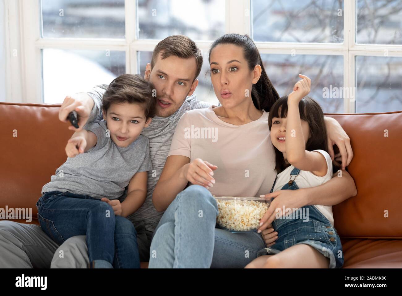 Junge Eltern genießen Film Zeit zu Hause mit kleinen Kindern Stockfoto