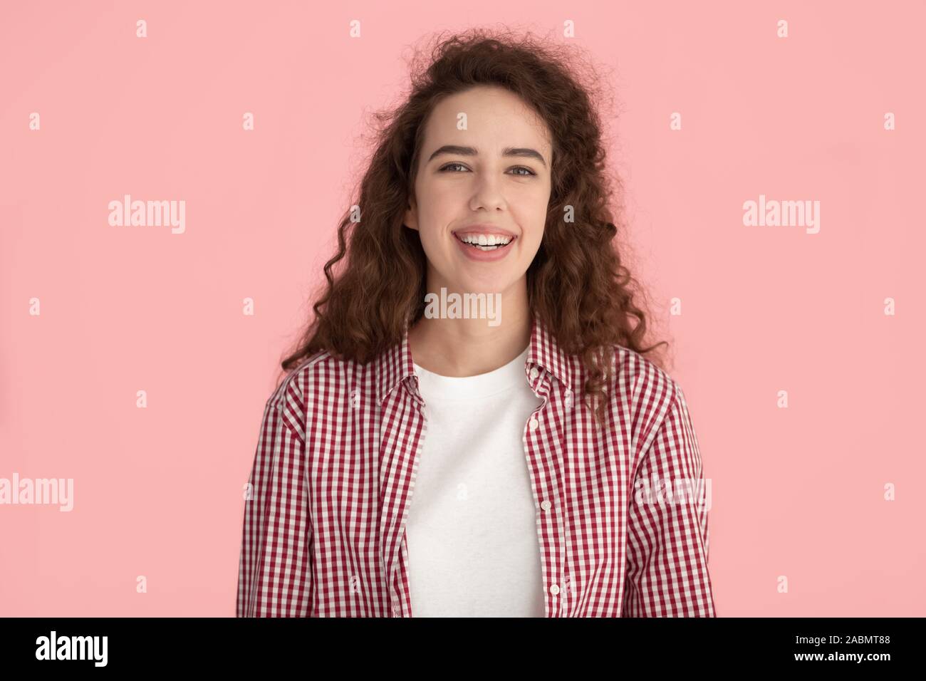 Happy tausendjährigen Mädchen lachend auf rosa Hintergrund posiert Stockfoto