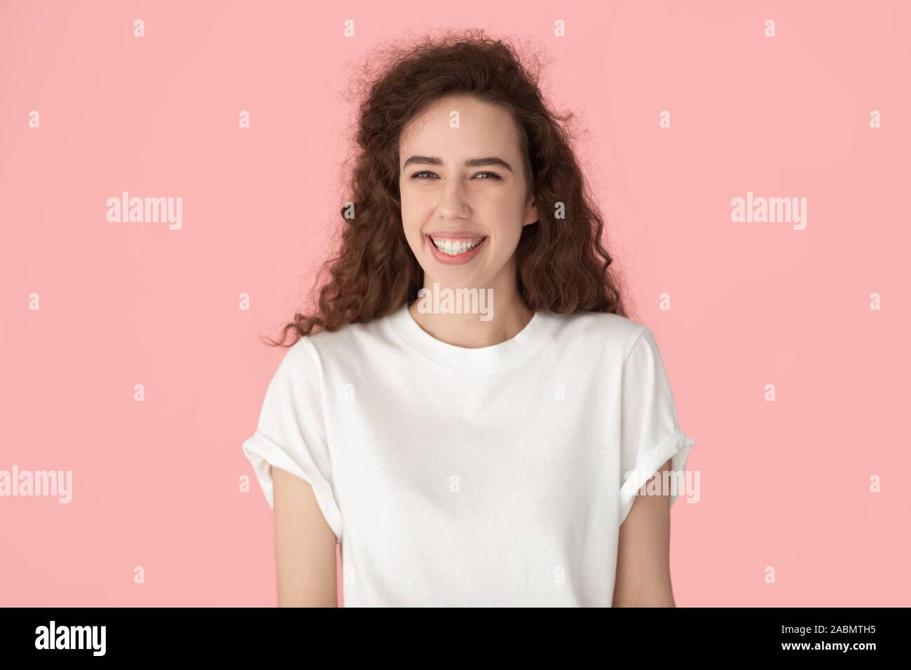Portrait von lächelnden tausendjährigen Mädchen auf rosa Hintergrund posiert Stockfoto