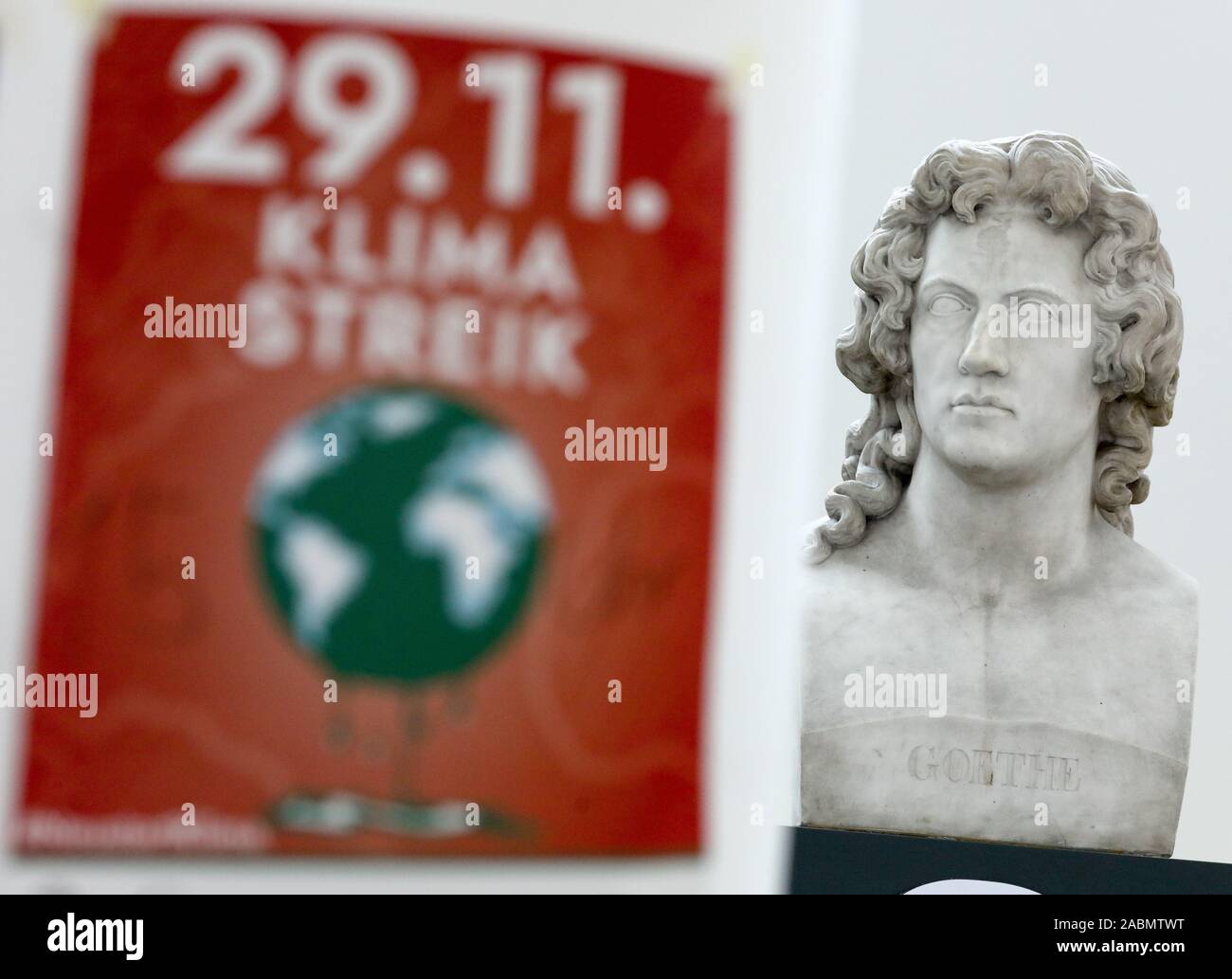 Leipzig, Deutschland. 28 Nov, 2019. Ein Poster' 29.11. Klima Strike' Hängt eine Spalte vor der Büste von Johann Wolfgang von Goethe während der Climate Action Woche im neuen Augusteum der Universität Leipzig. Mit Mahnwachen, Menschenketten und Blockaden, Klima Aktivisten wollen für einen sofortigen Abzug aus Braunkohle in der Leipziger Kohle Bezirk am Wochenende zu protestieren. Die Veranstalter erwarten mehrere hundert Demonstranten in der Gegend um Leipzig und in der Lausitz. Kredite: Jan Woitas/dpa-Zentralbild/dpa/Alamy leben Nachrichten Stockfoto