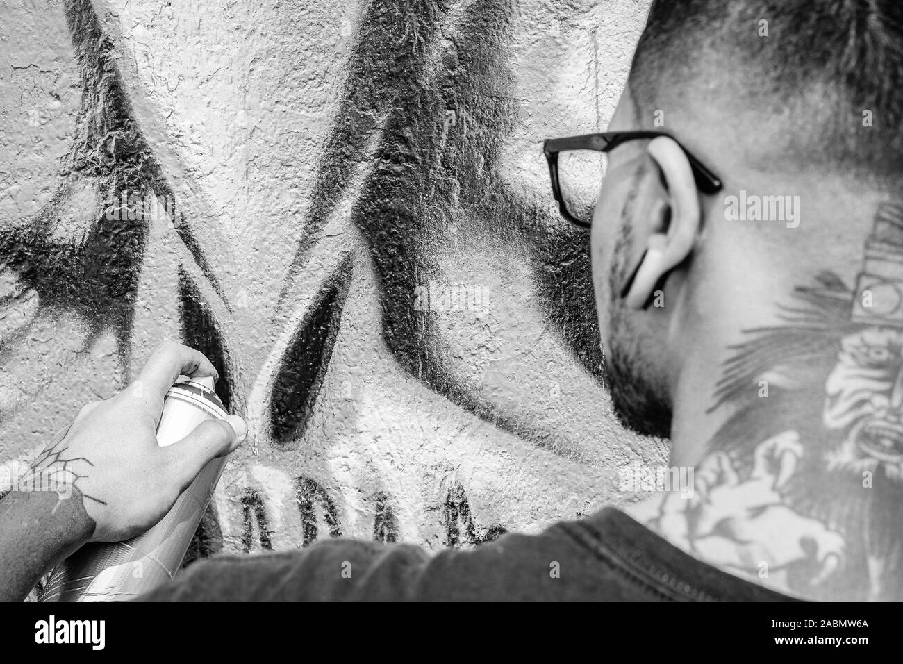 Street Graffiti Künstler Malen mit einem Color Spray kann eine dunkle Monster Schädel Graffiti an der Wand in der Stadt im Freien - in der Nähe von Hand bemalt Stockfoto