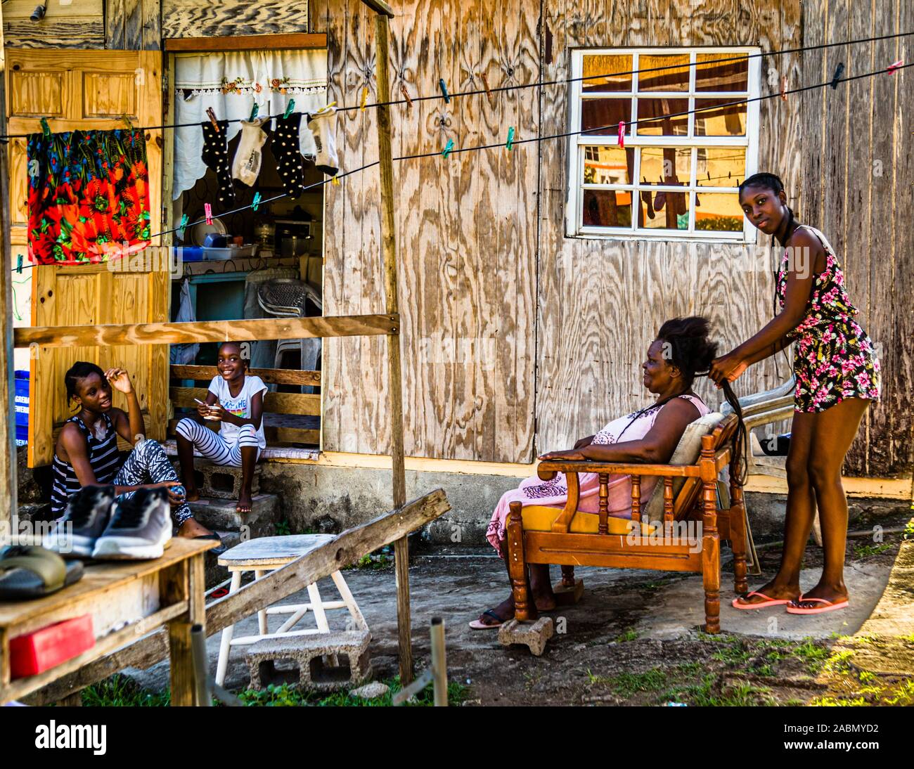 In Happy Hill machen die Einheimischen die Frisur füreinander. In Grenada findet das Leben zum größten Teil im Freien statt Stockfoto
