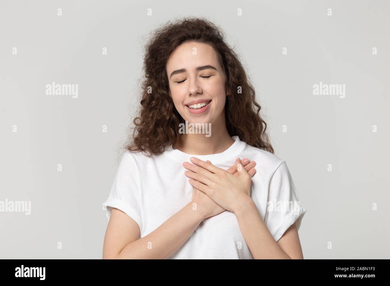 Dankbar tausendjährigen Mädchen mit den Händen an die Brust fühlen Dankbarkeit Stockfoto