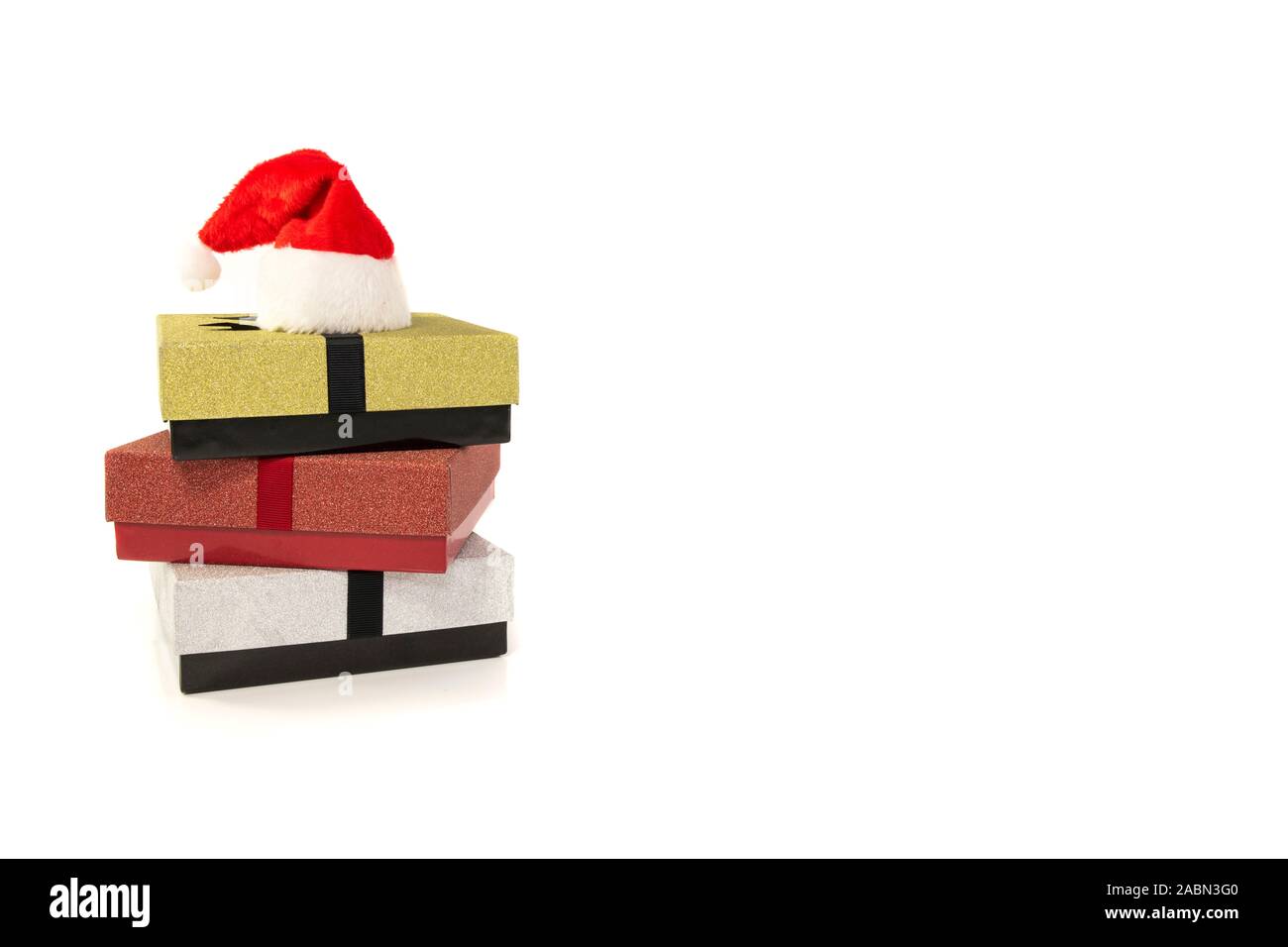 Drei Geschenkboxen in Rot Silber und Gold mit santa claus Hut auf weißem Hintergrund Stockfoto