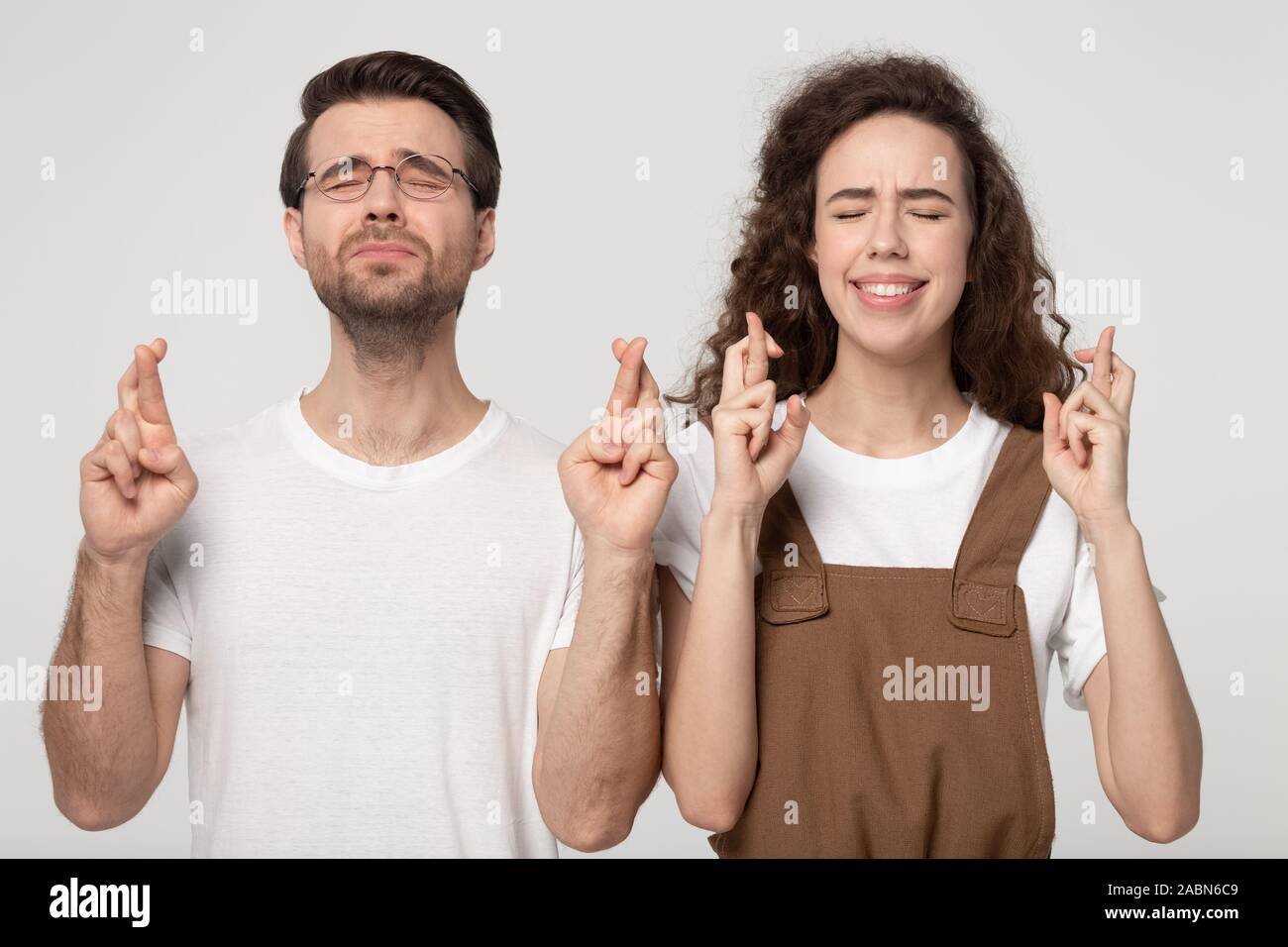 Hoffnungsvolle junge Paar kreuz Finger zusammen machen möchten Stockfoto