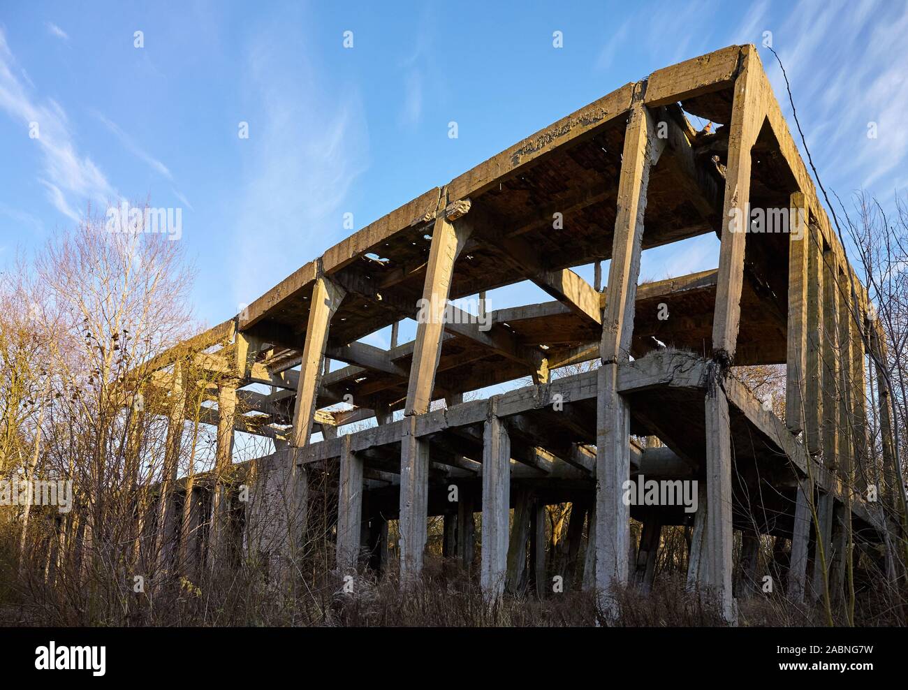 Ruiniert konkrete industrielle Struktur im Wald bei Sonnenuntergang. Stockfoto