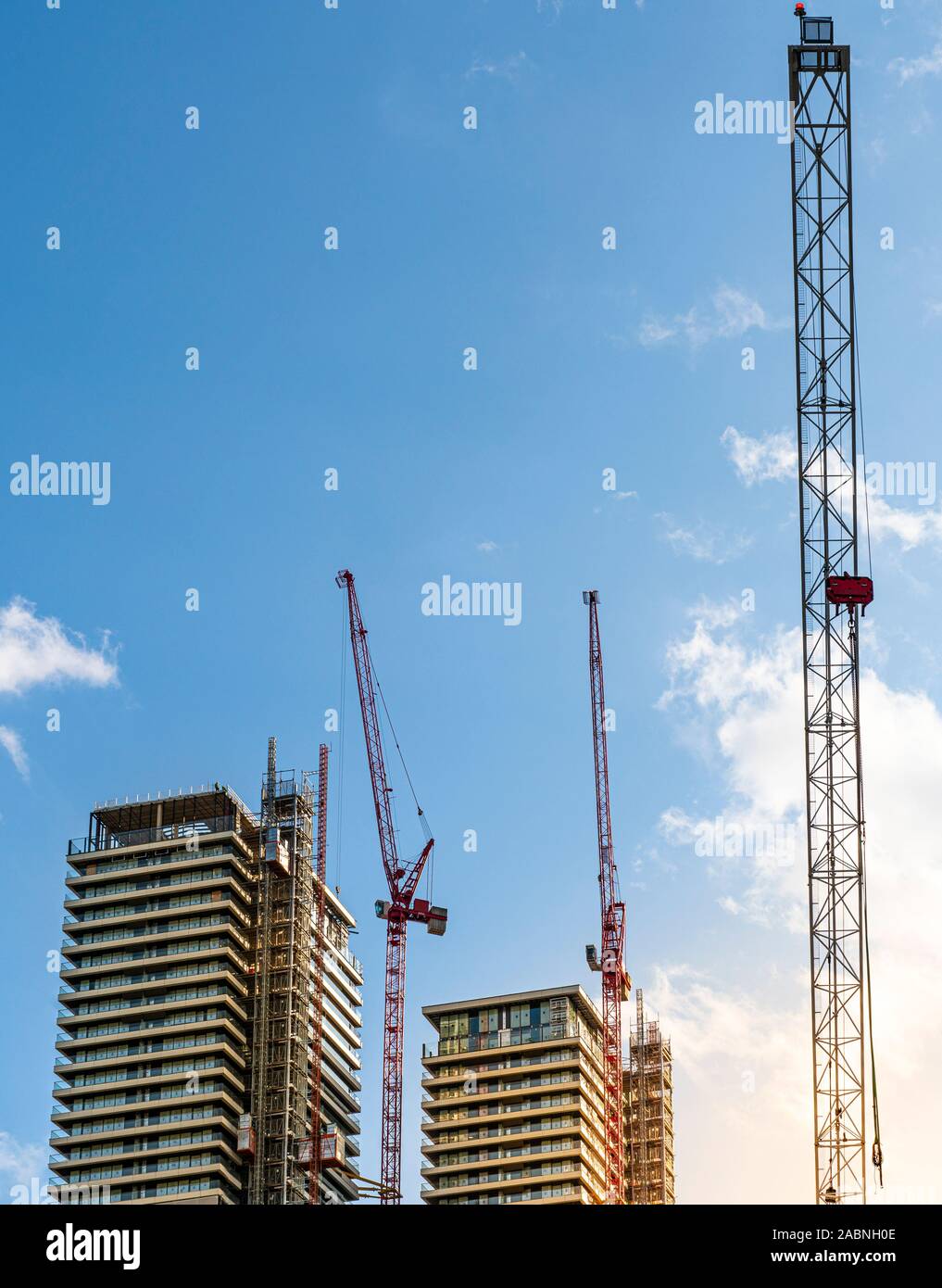 Zwei große Bürotürme im Bau mit drei großen Kräne an einem klaren Tag bei Sonnenaufgang, London, England Stockfoto