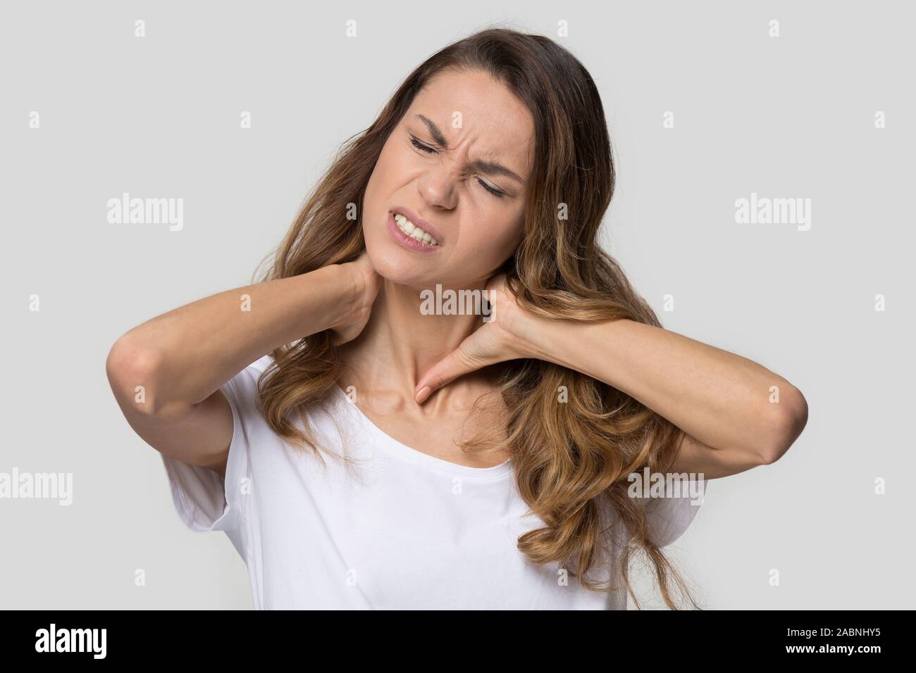 Müde, erschöpft, junge Frau massieren der verspannten Muskeln des Halses Stockfoto