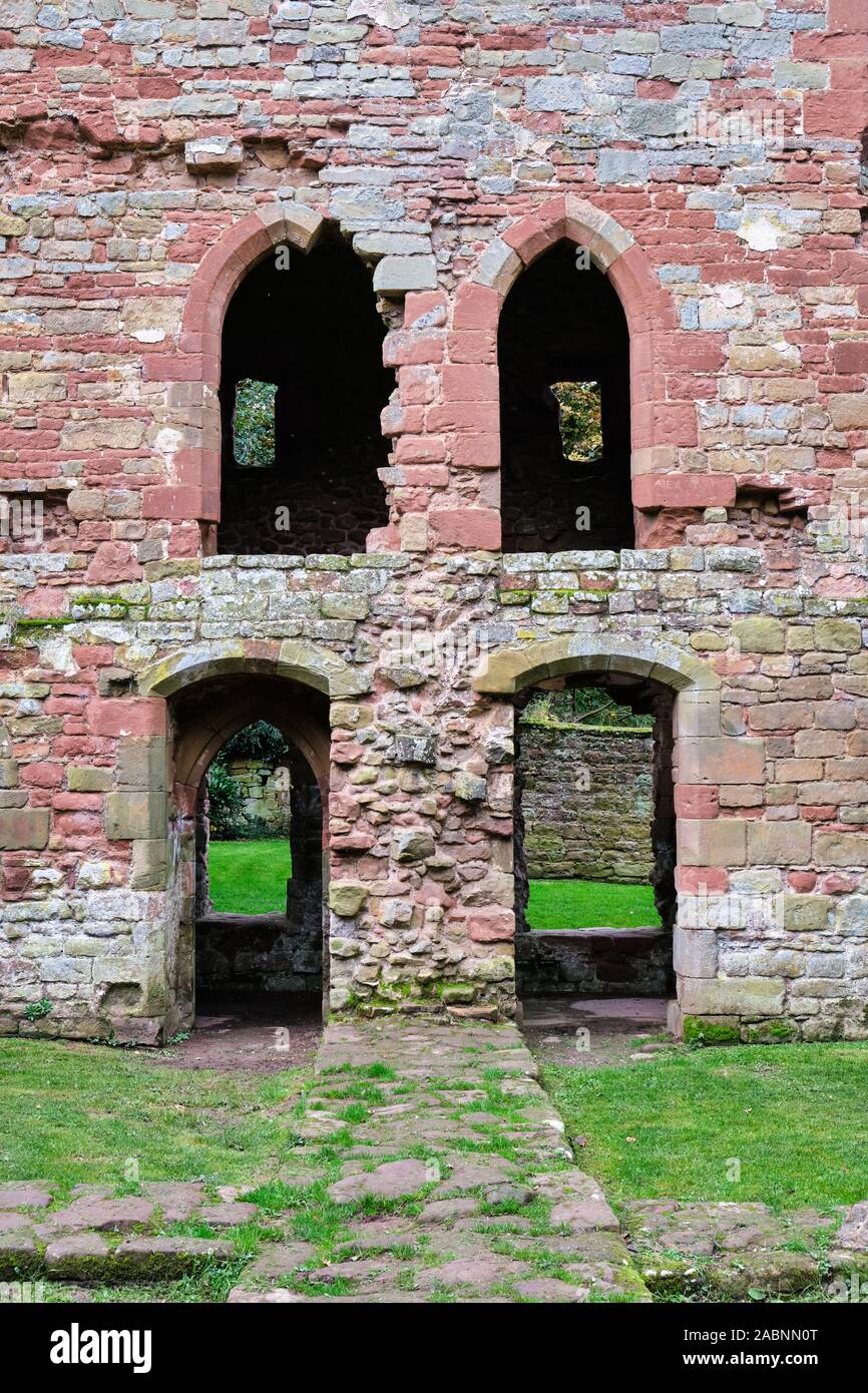 Symmetrische gewölbten Fenstern und Türen auf zwei Ebenen in einem zerstörten roten Sandstein Mauer in die Überreste von Acton Burnell Schloss in Shropshire England Stockfoto