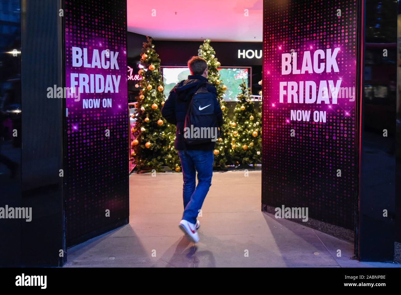 London, Großbritannien. 28. November 2019. Ein Käufer außerhalb des House of Fraser Kaufhaus, die Förderung der Rabatte in der Oxford Street, dem größten Einkaufsviertel der Stadt, am Vorabend der Schwarze Freitag. Die US-Phänomen der Ermäßigungen für Thanksgiving hat jetzt von vielen Einzelhändlern im Vereinigten Königreich mit mehreren Rabatte während der vorherigen Woche verabschiedet worden, anstatt am Tag selbst. Kritiker fragen, ob einige Ermäßigungen auf den Tag angeboten werden, sind günstiger als zu anderen Zeiten. Credit: Stephen Chung/Alamy leben Nachrichten Stockfoto