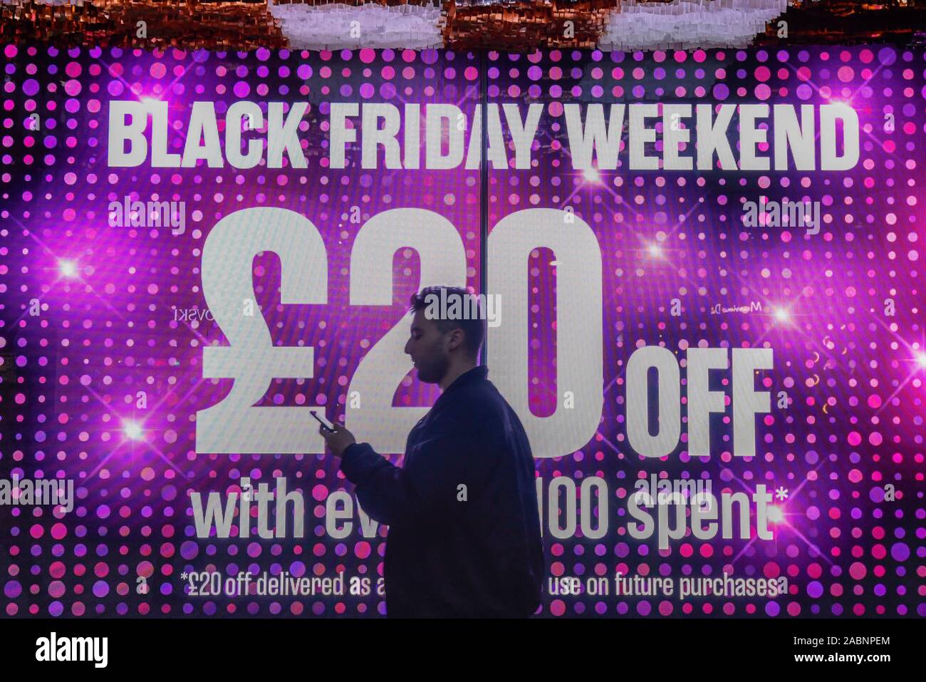 London, Großbritannien. 28. November 2019. Ein Käufer außerhalb des House of Fraser Kaufhaus, die Förderung der Rabatte in der Oxford Street, dem größten Einkaufsviertel der Stadt, am Vorabend der Schwarze Freitag. Die US-Phänomen der Ermäßigungen für Thanksgiving hat jetzt von vielen Einzelhändlern im Vereinigten Königreich mit mehreren Rabatte während der vorherigen Woche verabschiedet worden, anstatt am Tag selbst. Kritiker fragen, ob einige Ermäßigungen auf den Tag angeboten werden, sind günstiger als zu anderen Zeiten. Credit: Stephen Chung/Alamy leben Nachrichten Stockfoto