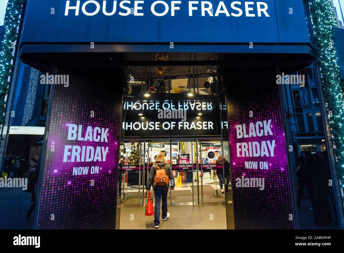 London, Großbritannien. 28. November 2019. Ein Käufer außerhalb des House of Fraser Kaufhaus, die Förderung der Rabatte in der Oxford Street, dem größten Einkaufsviertel der Stadt, am Vorabend der Schwarze Freitag. Die US-Phänomen der Ermäßigungen für Thanksgiving hat jetzt von vielen Einzelhändlern im Vereinigten Königreich mit mehreren Rabatte während der vorherigen Woche verabschiedet worden, anstatt am Tag selbst. Kritiker fragen, ob einige Ermäßigungen auf den Tag angeboten werden, sind günstiger als zu anderen Zeiten. Credit: Stephen Chung/Alamy leben Nachrichten Stockfoto
