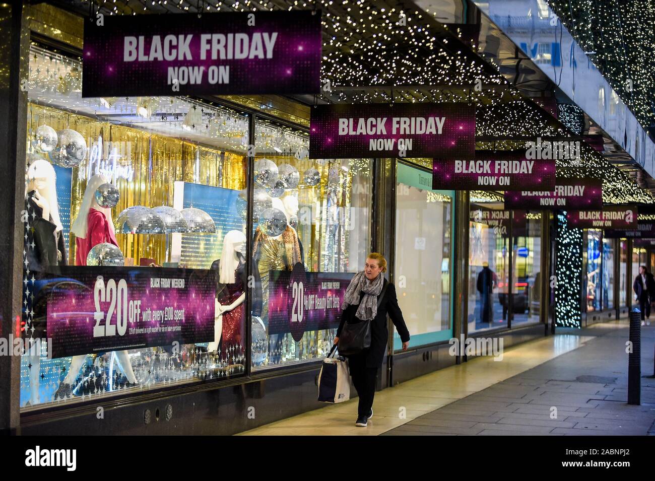 London, Großbritannien. 28. November 2019. Ein Käufer außerhalb des House of Fraser Kaufhaus, die Förderung der Rabatte in der Oxford Street, dem größten Einkaufsviertel der Stadt, am Vorabend der Schwarze Freitag. Die US-Phänomen der Ermäßigungen für Thanksgiving hat jetzt von vielen Einzelhändlern im Vereinigten Königreich mit mehreren Rabatte während der vorherigen Woche verabschiedet worden, anstatt am Tag selbst. Kritiker fragen, ob einige Ermäßigungen auf den Tag angeboten werden, sind günstiger als zu anderen Zeiten. Credit: Stephen Chung/Alamy leben Nachrichten Stockfoto