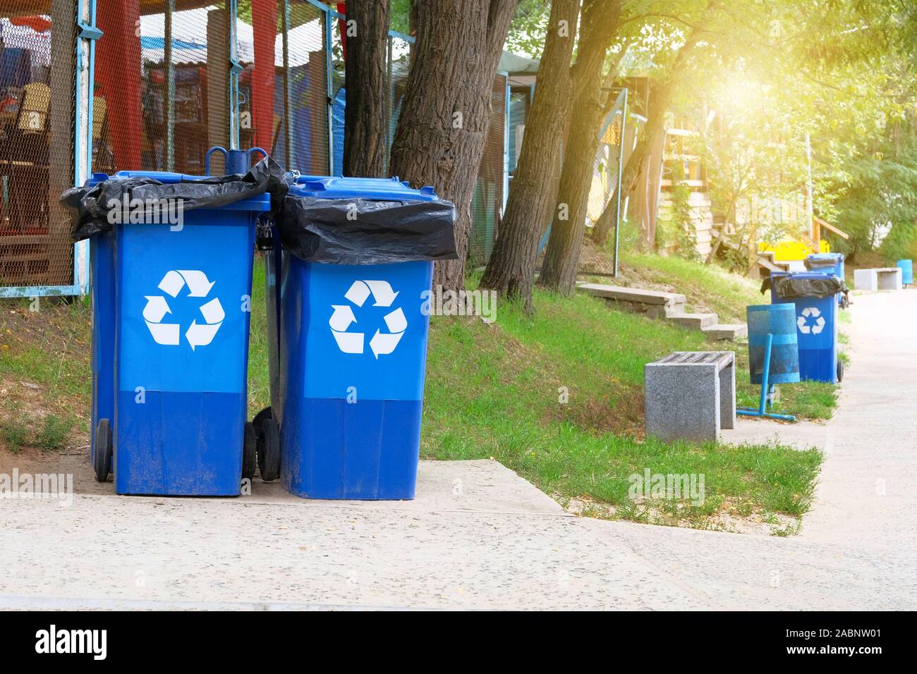 Garbage Collection. Den blauen Container für die weitere Verarbeitung von Müll. Recycling von Abfällen Konzept. Sonnenschein. Stockfoto