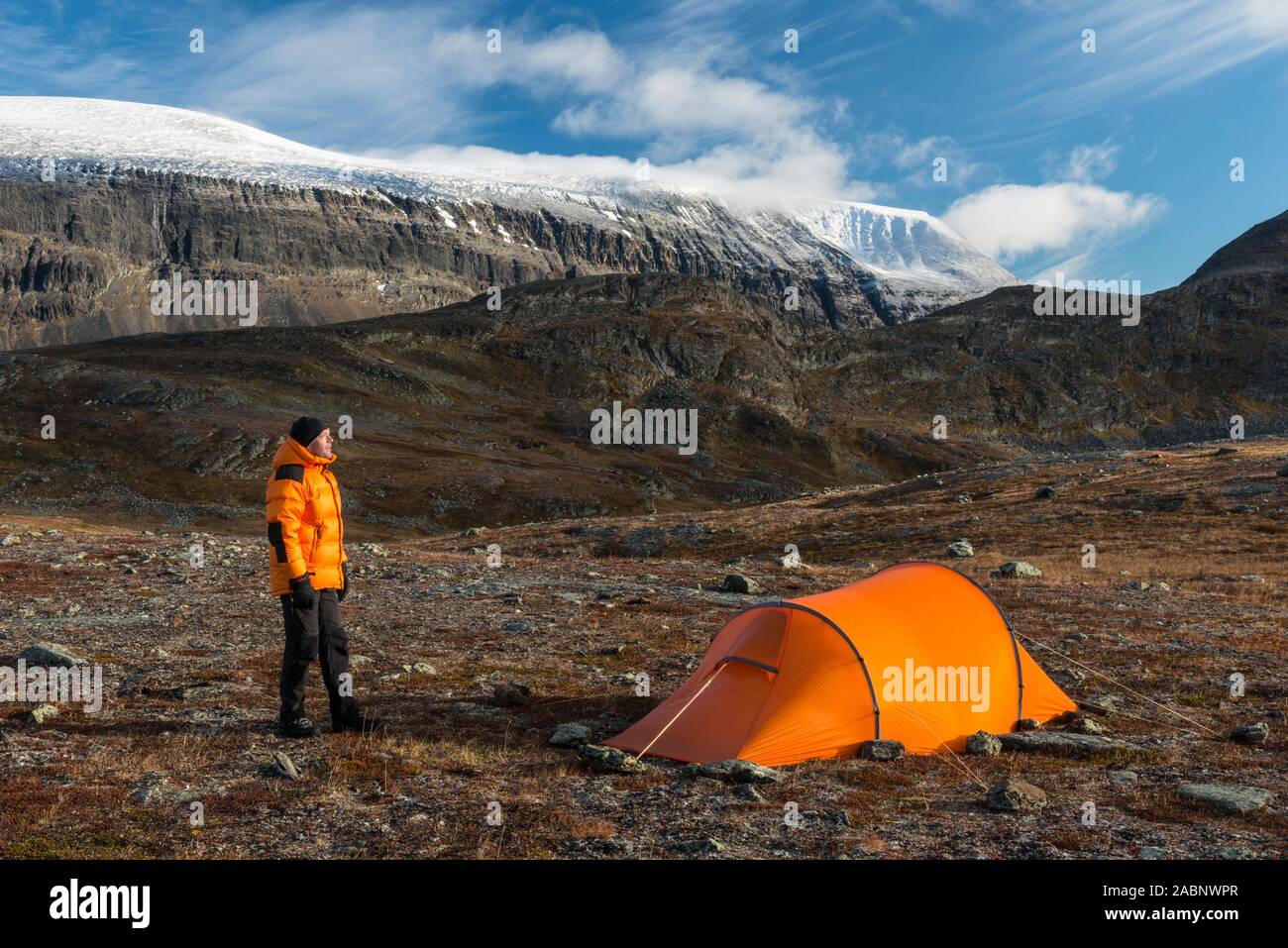 Mann neben Zelt mit Blick auf den Berg, Sinnitjohkka Kebnekaisefjaell, Norrbotten, Lappland, Schweden, September 2012 Stockfoto