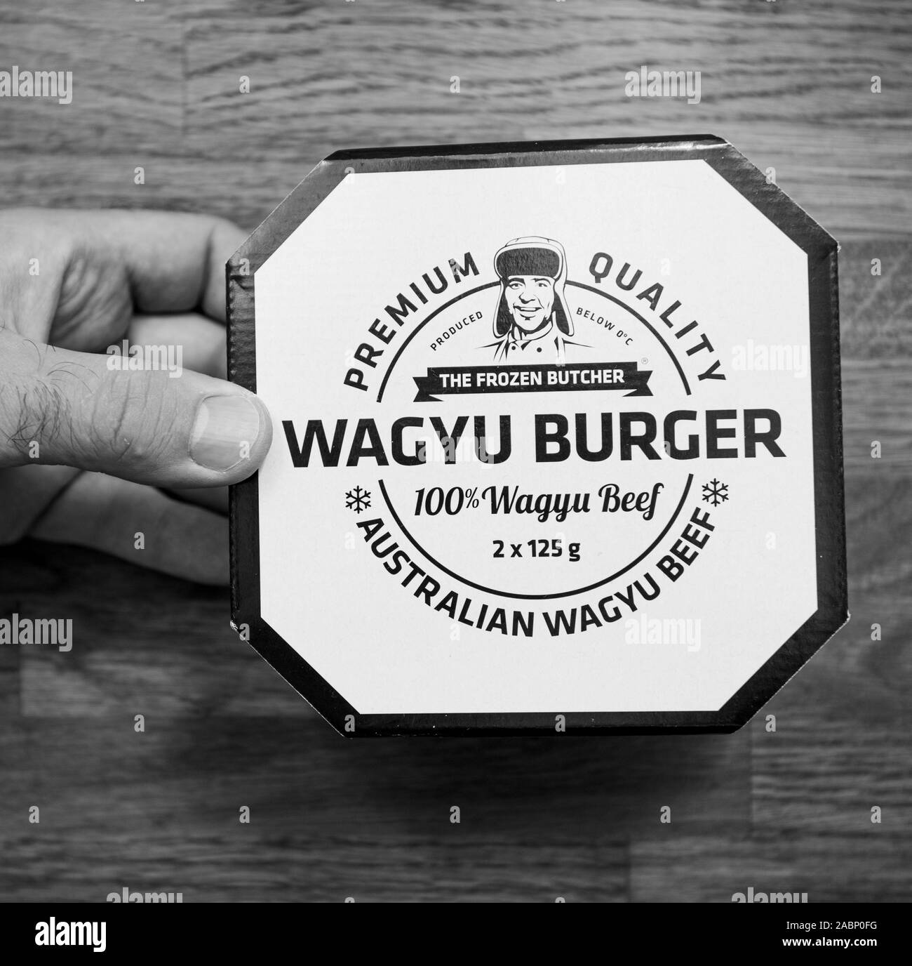 Paris, Frankreich - Okt 4, 2019: Über Sicht des Menschen Hand über den Küchentisch Wagyu Burger mit Premium Qualität von australischen Wagyu Beef aus schwarzen und weißen rechteckigen Bild Stockfoto