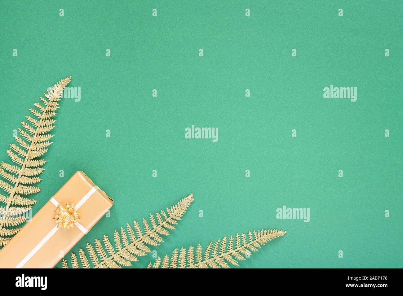 Festliche grüner Hintergrund mit gold Dekoration, Hintergrund mit Glitzer glänzenden goldenen Farnblätter und Geschenkboxen, Flach, Ansicht von oben, kopieren Raum Stockfoto